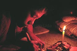 ビルマからタイ側に渡った直後、不自由な難民キャンプの中、ロウソクの灯のもとで勉強する『彼』。